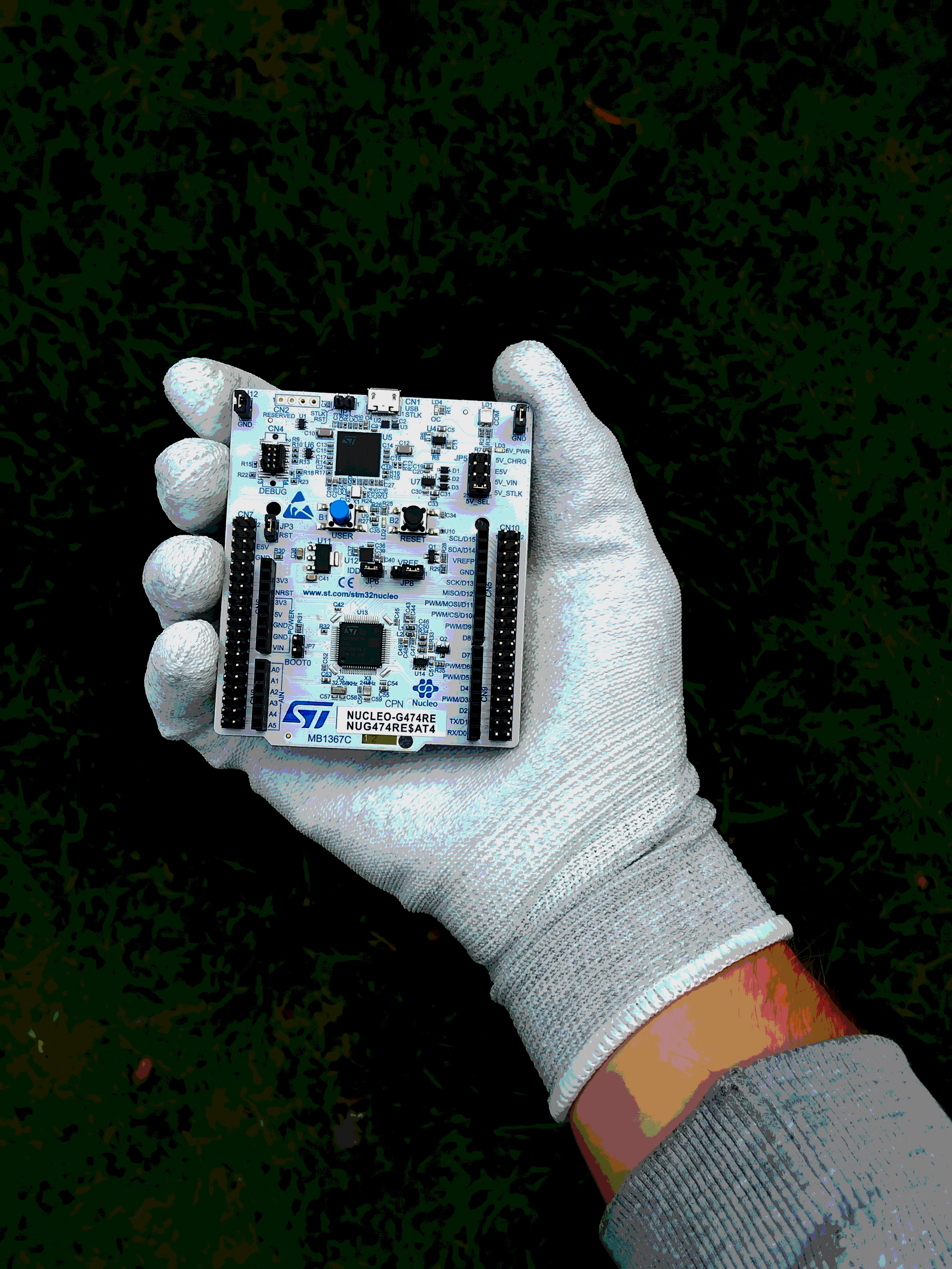 My hand holding STM32G474RE with anti ESD gloves